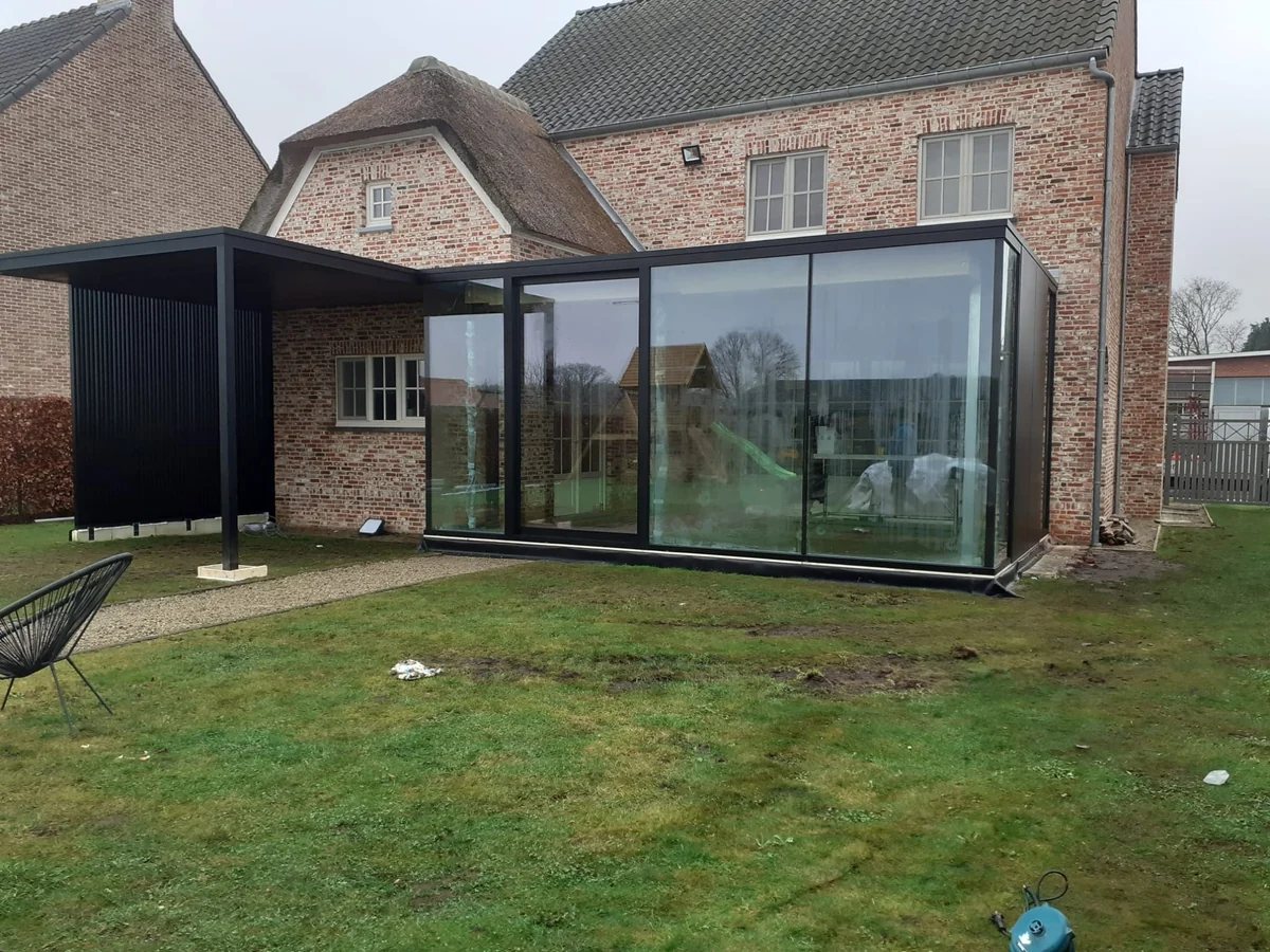 Auvent en aluminium avec parois en verre sur une maison