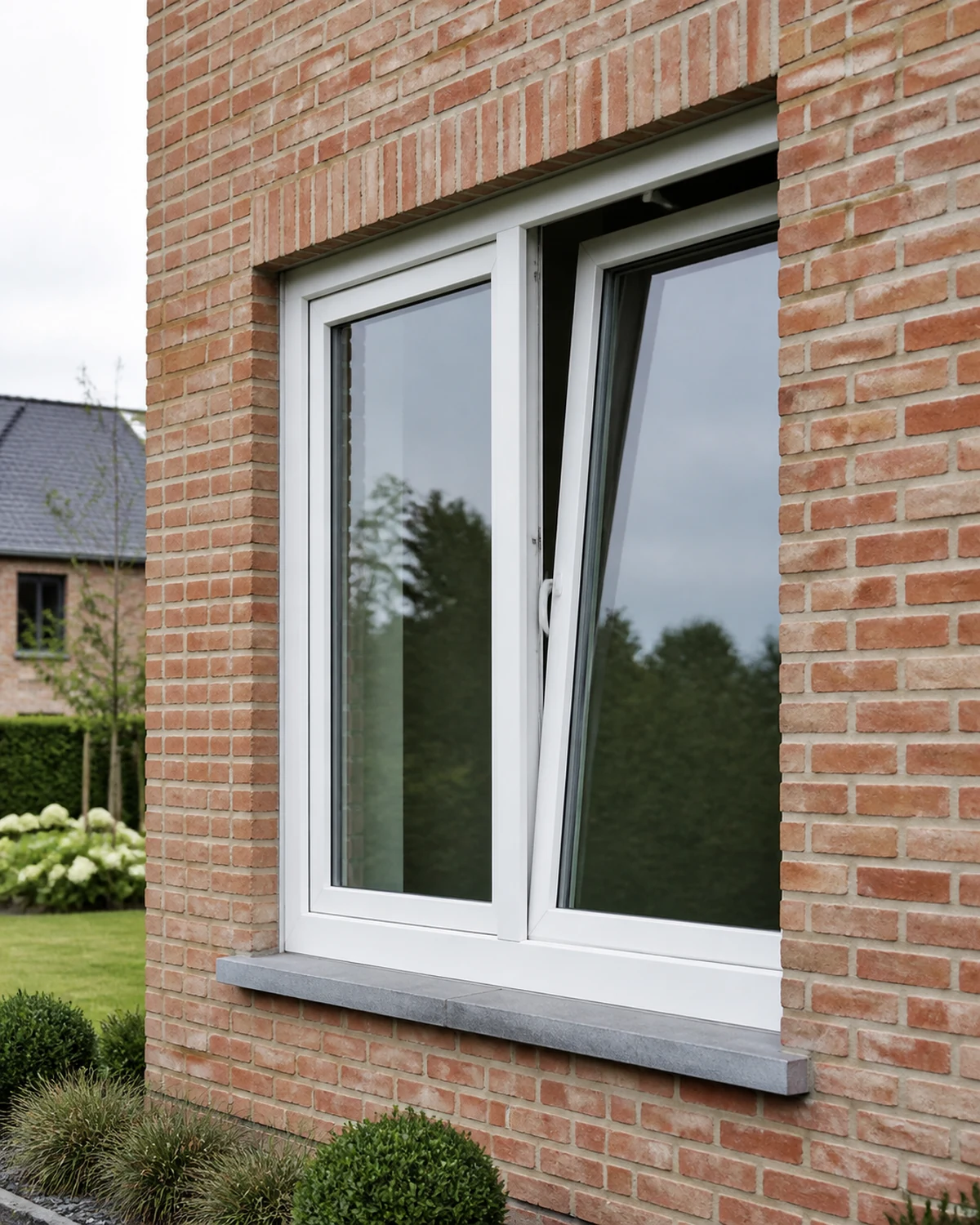 Wit PVC draai-kiepraam in een Belgische baksteengevel